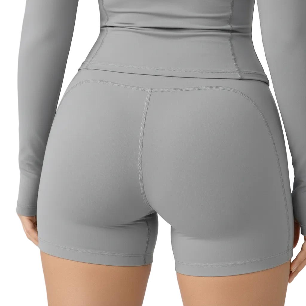 Gray athletic outfit with shorts and long-sleeve top on a plain background