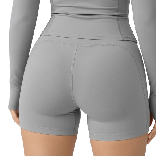 Gray athletic outfit with shorts and long-sleeve top on a plain background