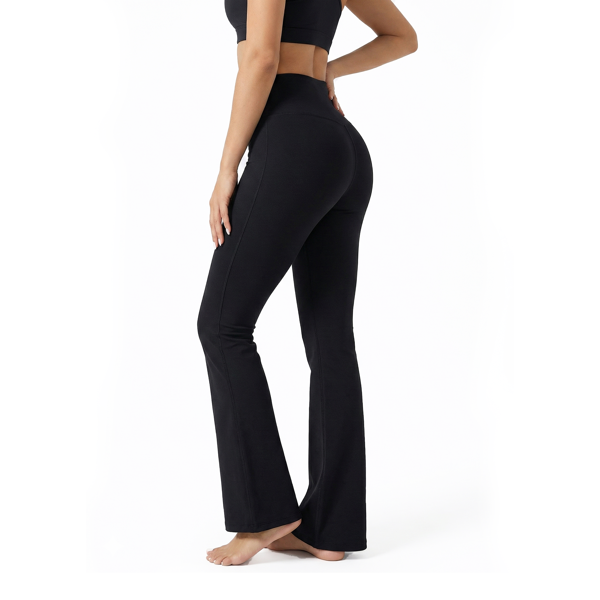 Person wearing black flared leggings on a white background