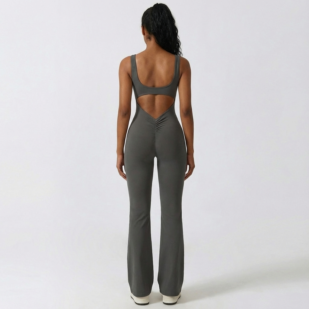 Person wearing a gray jumpsuit with cut-out design on a white background