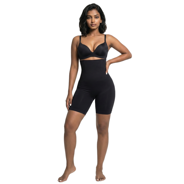 Woman wearing black high waist shaping shorts on a white background, front view