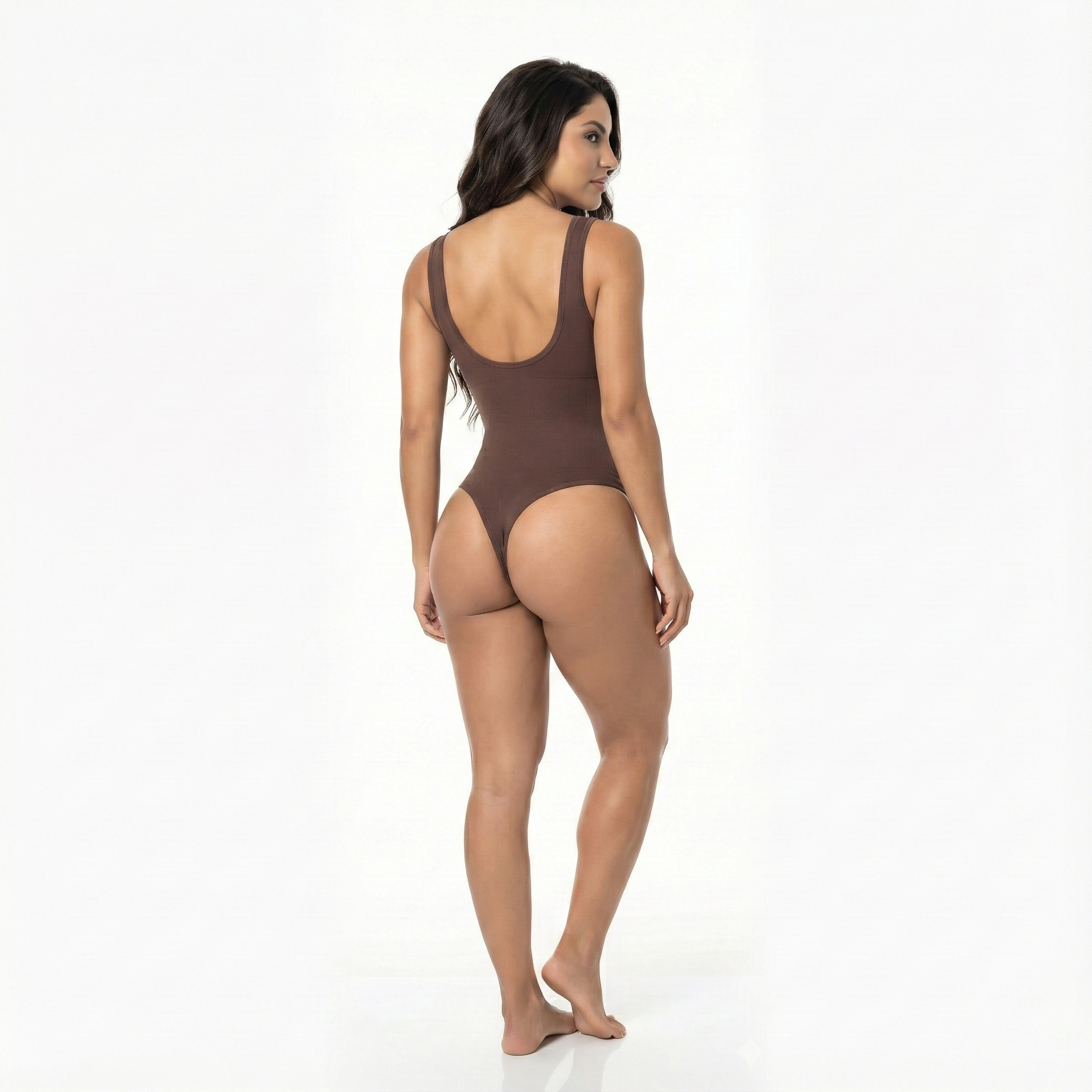 Woman wearing a brown thong bodysuit on a white background, back view