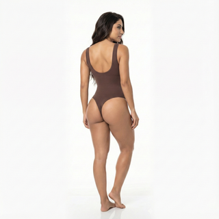 Woman wearing a brown thong bodysuit on a white background, back view