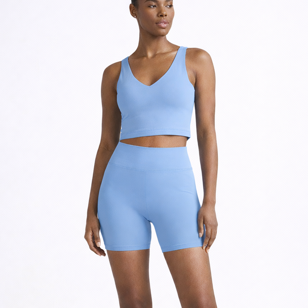 Woman wearing a light blue athletic outfit on a white background