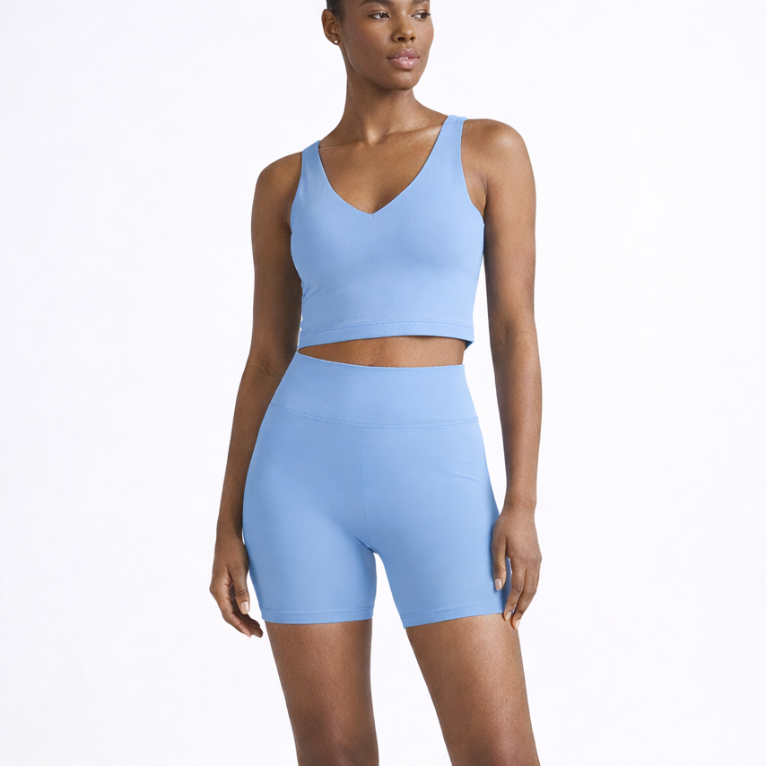 Woman wearing a light blue athletic outfit on a white background