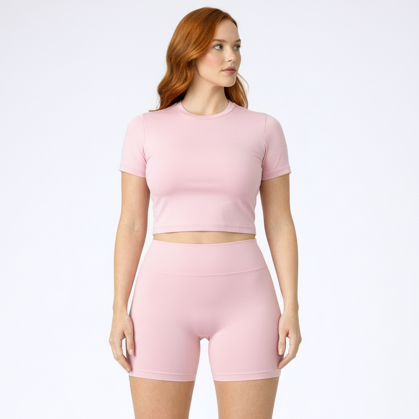 Woman wearing a pink athletic outfit on a white background