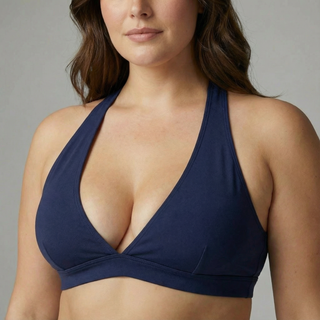 Woman wearing a navy blue bikini top against a neutral background